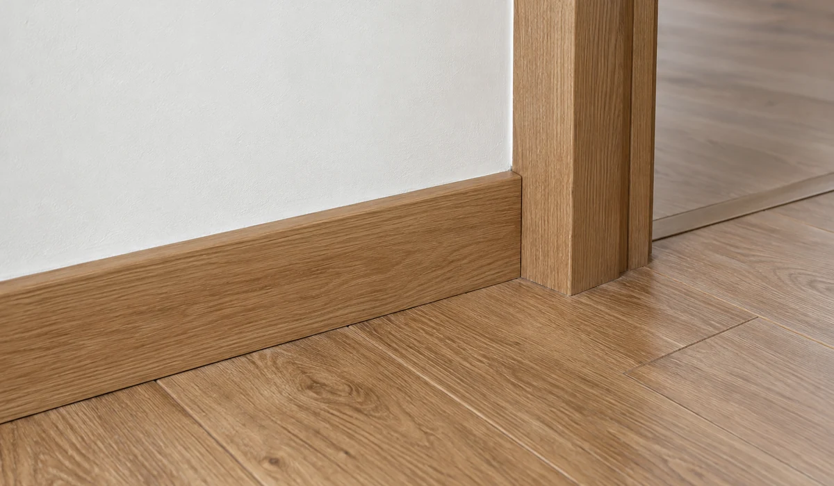 Illustration d’une jonction intacte entre parquet, plinthe en bois, dormant de porte et mur minéral